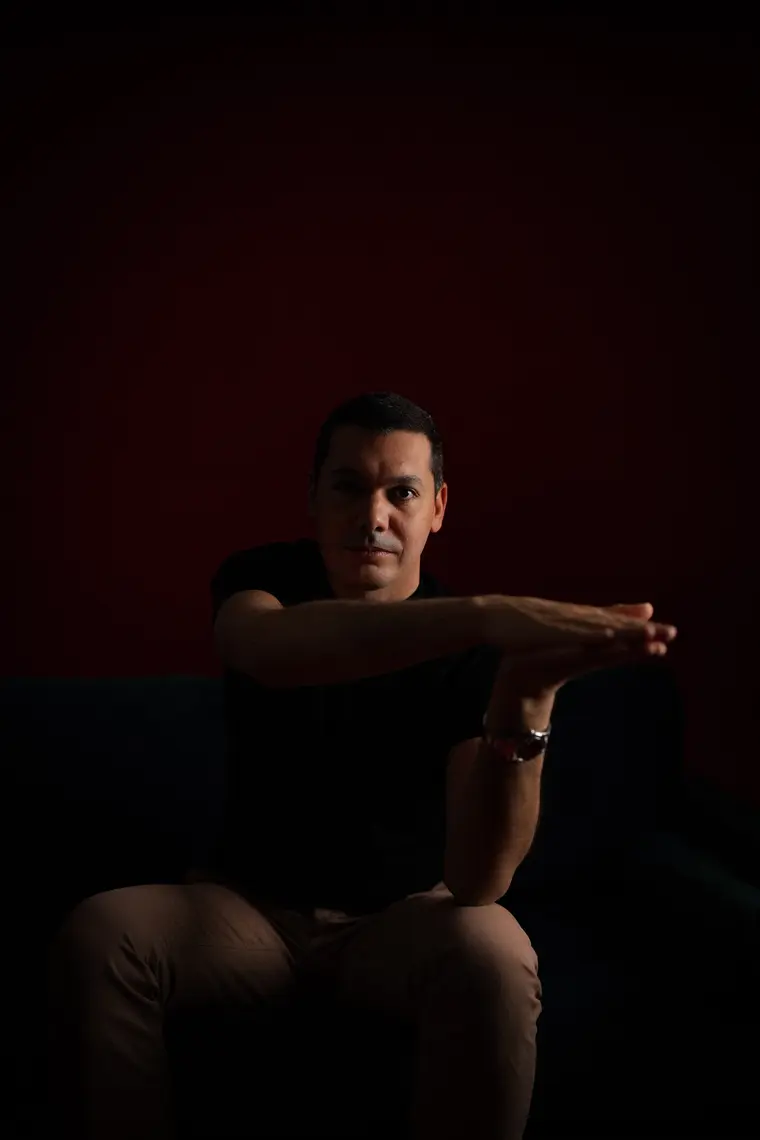 Simon Daragon sur fond rouge, geste suspendu